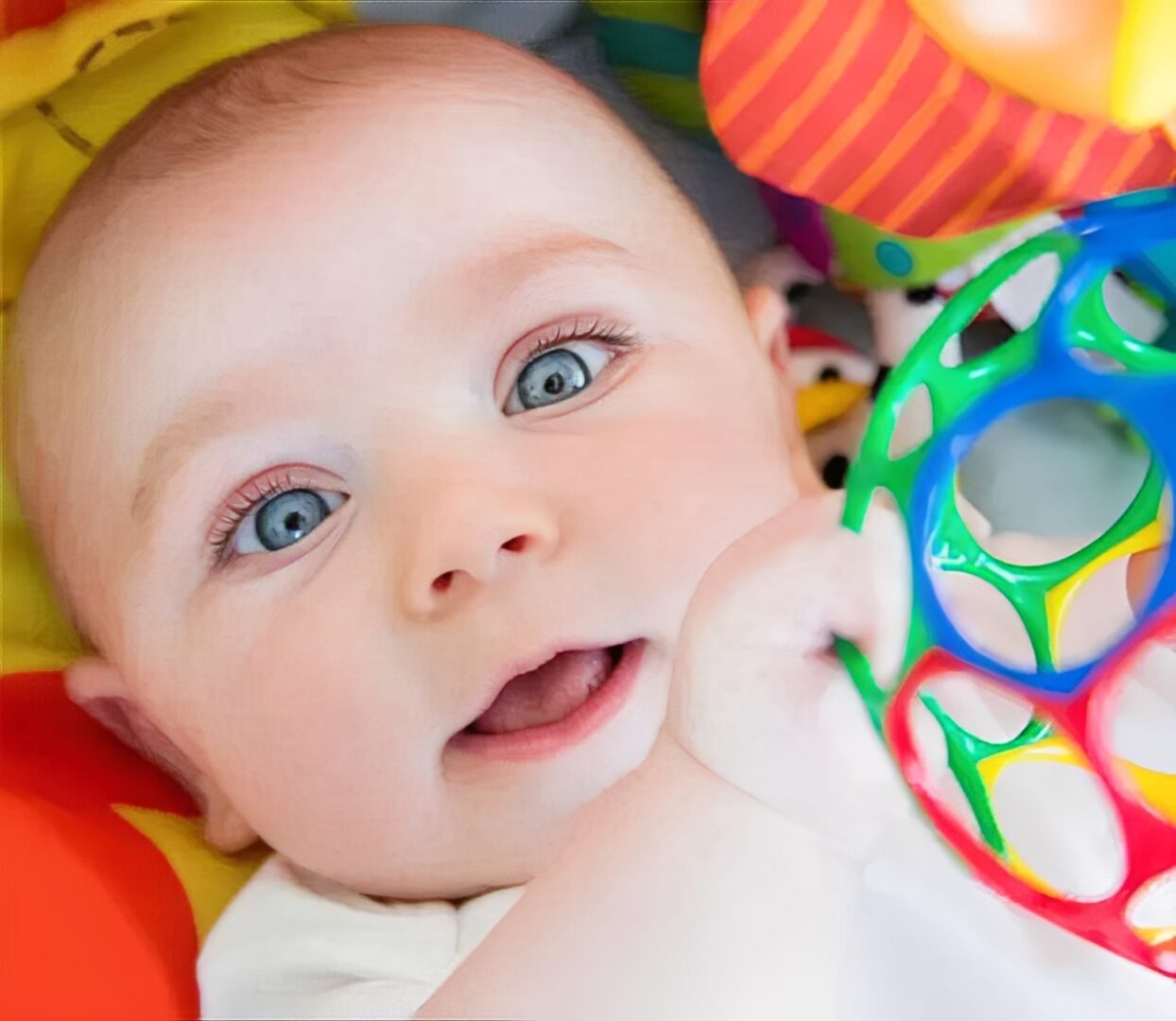 Infant holding a vibrant ball