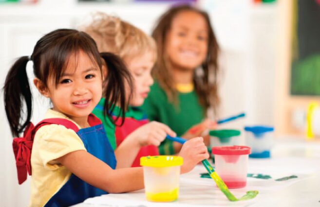 Smiling children with paintbrushes