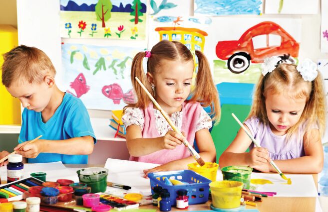 Young artists painting with brushes and paints